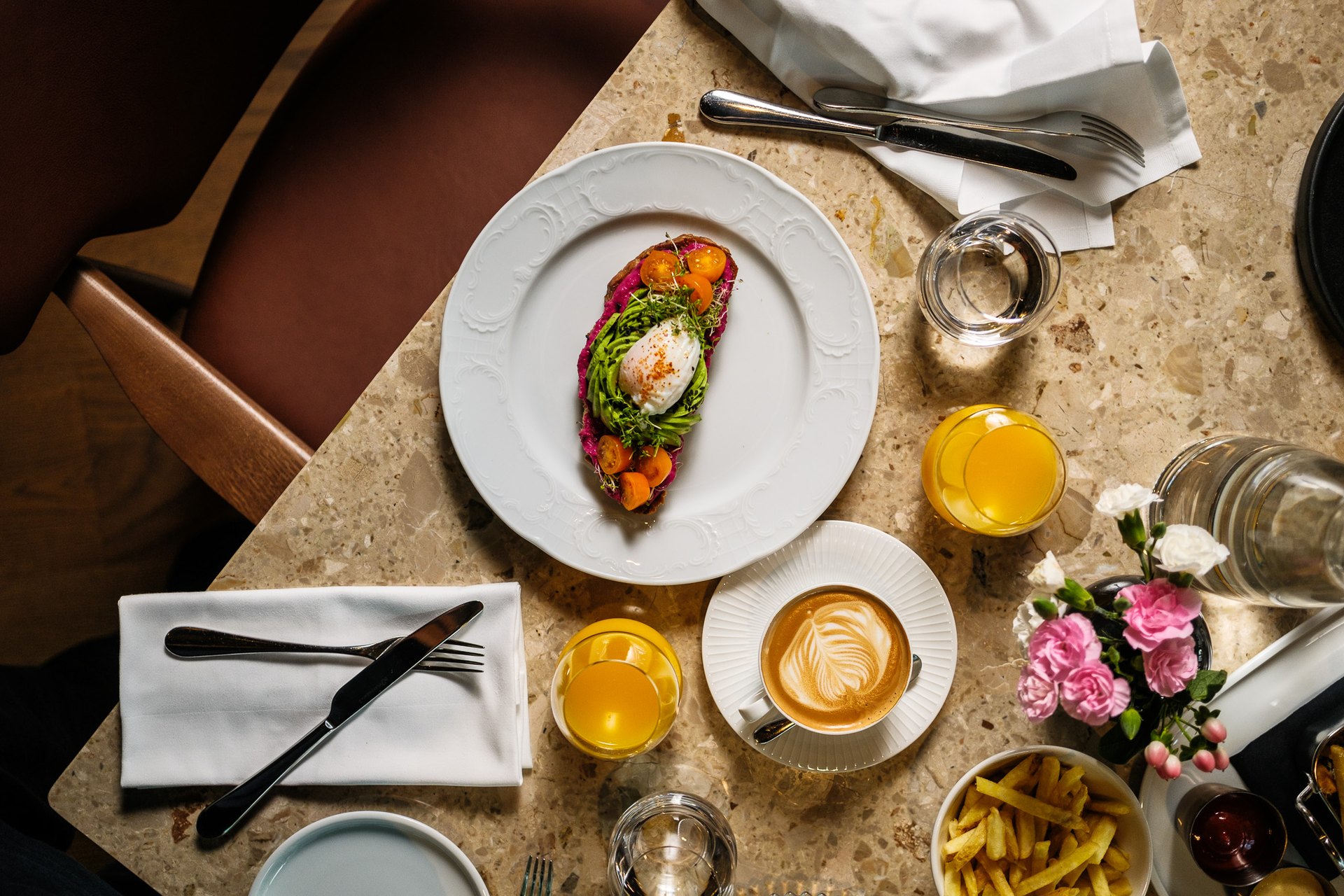 Breakfast at The Thief: a poached egg on toast, coffee and orange juice on a terrazzo table